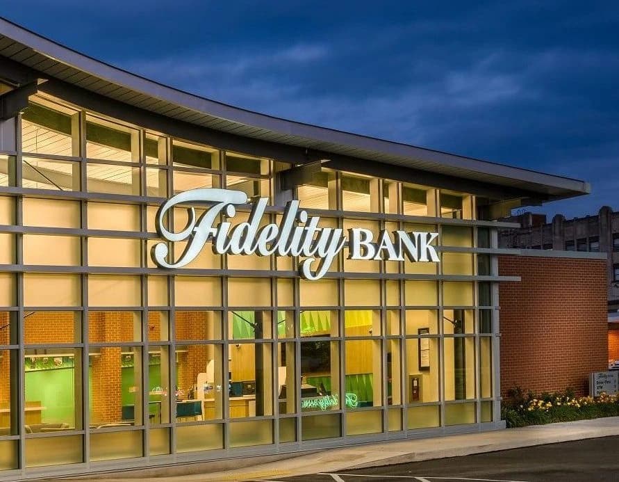 Fidelity Bank branch exterior lit at dusk